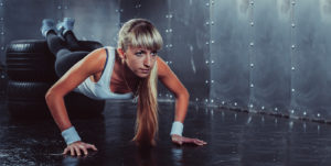 sporty athlete woman doing push ups on tire strength power training concept cross fit fitness workout sport and lifestyle